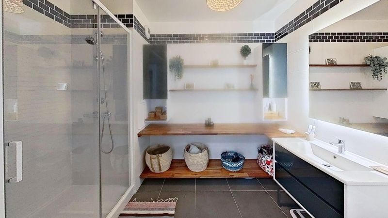 Salle de bains avec douche à l'italienne, meuble vasque et rangements