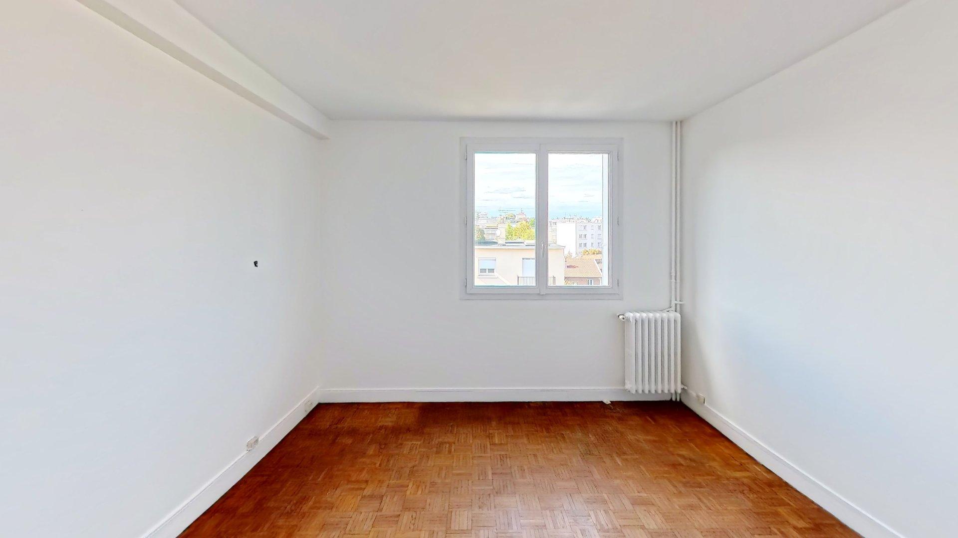 Chambre claire avec parquet et fenêtre