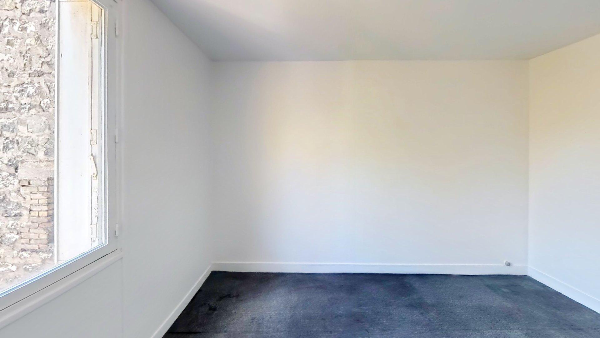 Chambre vide avec grande fenêtre